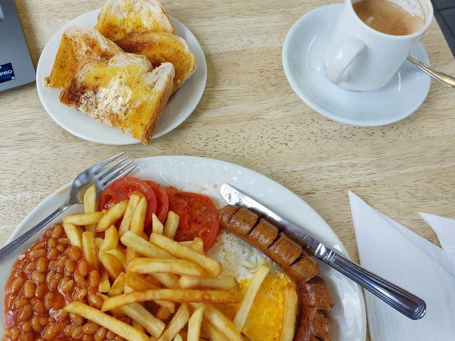 All-day breakfast with a side plate of toast and a cup of tea